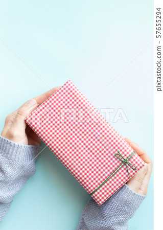 Woman's hands in sweater holding gift box. Woman's hands in sweater holding gift box. 57655294