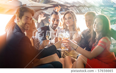 Group of women and men clinking glasses in a limousine Group of women and men clinking glasses in a limousine 57656665