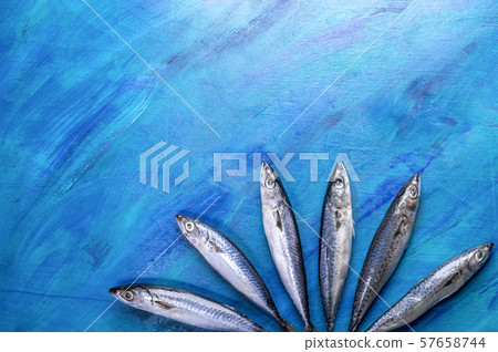 Mackerel fishes laid out as fan on painted blue background. Raw fishes pattern, top view, flat lay, copy space. 57658744
