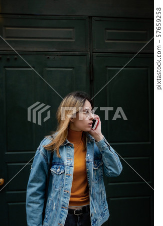 Blonde girl is walking on city street 57659258