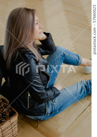 A blonde woman in a black leather jacket is A blonde woman in a black leather jacket is 57660025
