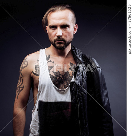 A man with tattooes on his arms. Silhouette of muscular body. caucasian brutal hipster guy with 57661529