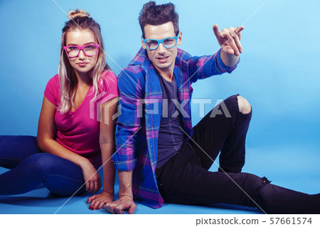 happy couple together posing cheerful on blue background wearing glasses, guy and girl students happy couple together posing cheerful on blue background wearing glasses, guy and girl students 57661574