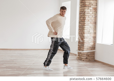 Athletic young man dancing in the white room Athletic young man dancing in the white room 57664600