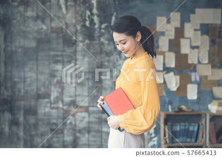 一個女人拿著一本書 57665413
