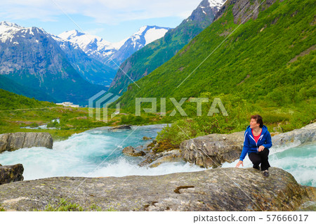 Tourist woman by Videfossen Waterfall in Norway 57666017