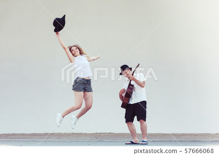 Man playing guitar, woman having fun Man playing guitar, woman having fun 57666068
