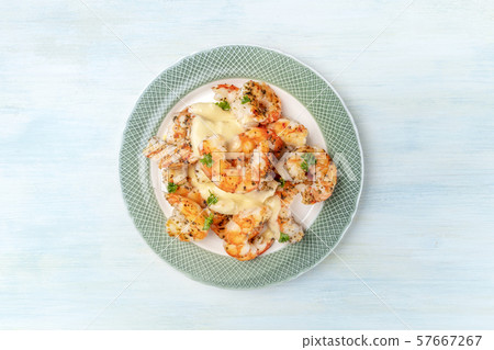Fired shrimps with a sauce, shot from the top on a light blue background with a place for text 57667267