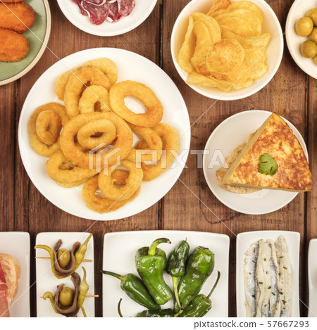 Spanish tapas, a variety of snacks. Squid rings, tortilla, sardines, gildas, padron peppers, square Spanish tapas, a variety of snacks. Squid rings, tortilla, sardines, gildas, padron peppers, square 57667293