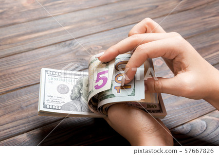 Perspective view of female hands counting money. Perspective view of female hands counting money. 57667826
