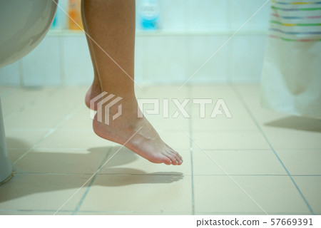 Closeup legs and feet of child siting and peeing Closeup legs and feet of child siting and peeing 57669391