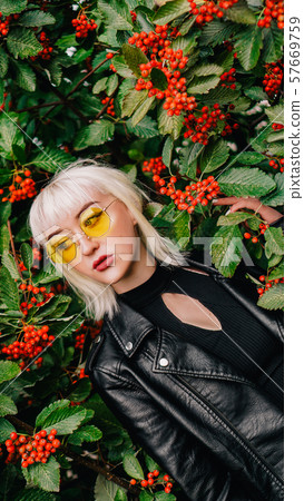 Portrait of young woman standing by rowan tree Portrait of young woman standing by rowan tree 57669759