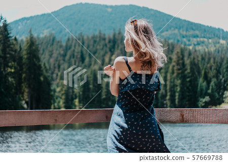 Smiling woman against mountain landscape and lake 57669788