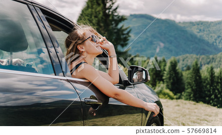 Happy woman travels by car in the mountains. Summer vacation concept 57669814