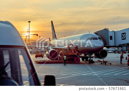 Modern passenger airplane parked to terminal building gate at airside apron of airport with close up Modern passenger airplane parked to terminal building gate at airside apron of airport with close up 57671981