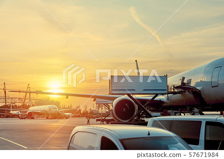 Modern passenger airplane parked to terminal building gate at airside apron of airport with close up Modern passenger airplane parked to terminal building gate at airside apron of airport with close up 57671984