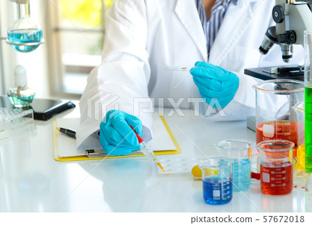 Young female doing experiments and researchers Young female doing experiments and researchers 57672018