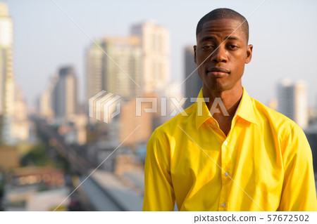 Young bald African businessman against view of the city 57672502