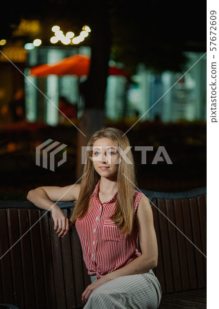 Nice girl on a bench in the evening in the park. 57672609