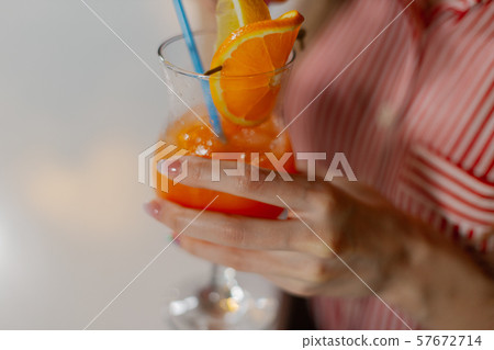 Beautiful girl with a bright fresh cocktail in a 57672714