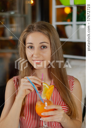 Beautiful girl with a bright fresh cocktail in a 57672728