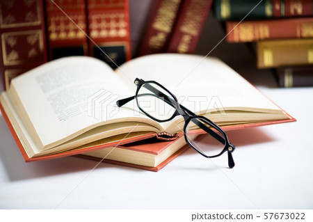 Stack of books with black men's glasses placed on Stack of books with black men's glasses placed on 57673022