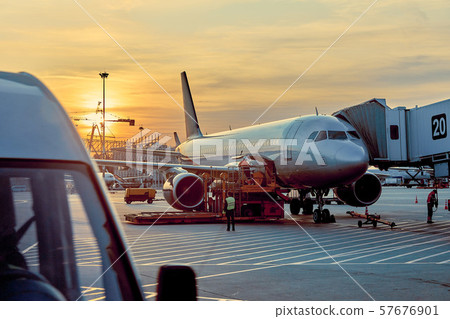 Modern passenger airplane parked to terminal building gate at airside apron of airport with close up Modern passenger airplane parked to terminal building gate at airside apron of airport with close up 57676901