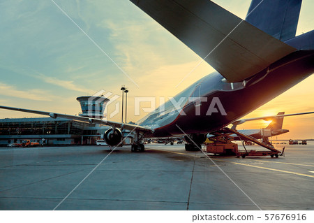 Modern passenger airplane parked to terminal building gate at airside apron of airport with close up Modern passenger airplane parked to terminal building gate at airside apron of airport with close up 57676916