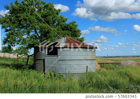 Grain Bin out in the Country with blue sky, and white cloud's. 57683343