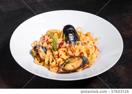 Homemade pasta with mussels, sprinkle with chopped parsley and basil. Delicious of pasta with mussel 57683526