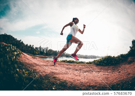 Woman trail runner running on seaside hills 57683670