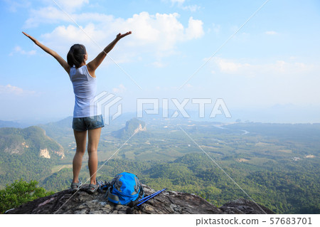 Successful woman hiker open arms at mountain top Successful woman hiker open arms at mountain top 57683701