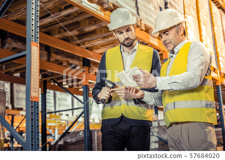 Attentive handsome manager standing near his colleague Attentive handsome manager standing near his colleague 57684020