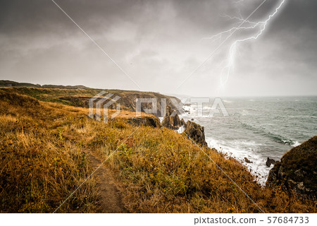 Lightning bolt strike from a thunderstorm near the sea Lightning bolt strike from a thunderstorm near the sea 57684733