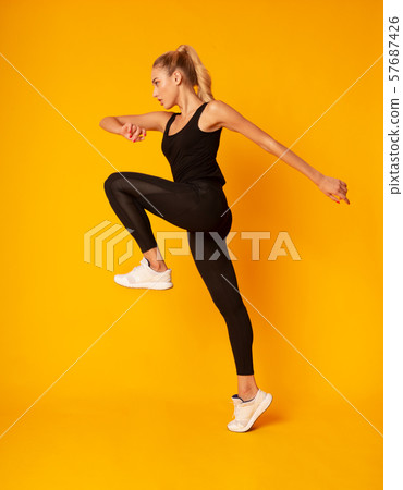 Fitness Girl Jumping During Cardio Workout, Studio Shot Fitness Girl Jumping During Cardio Workout, Studio Shot 57687426