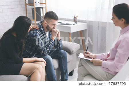 Caring wife comforting her stressed husband at psychological session 57687793