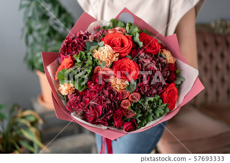 Beautiful bouquet of mixed flowers in womans hands. the work of the florist at a flower shop. Fresh Beautiful bouquet of mixed flowers in womans hands. the work of the florist at a flower shop. Fresh 57693333