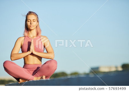 Woman meditating in the city Woman meditating in the city 57693499