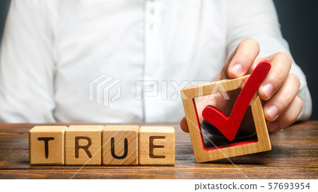 A man holds a red check mark over word True. Confirm the veracity and truth. Fight against fake news hostile propaganda. Confirmation facts, refutation of rumors. Debunking Myths and Misconceptions 57693954