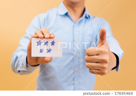 Businessman showing five stars card and thumbs up in bright yellow color background 57695469
