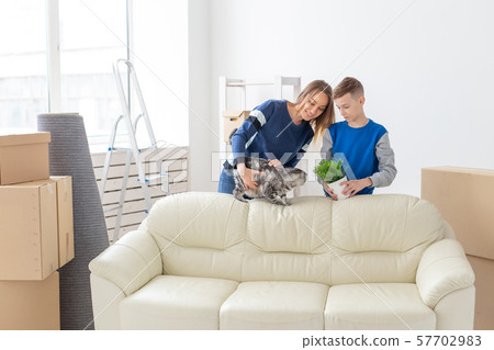 Young cute single mother and son are happy about the move to new house holding a lop-eared scottish 57702983