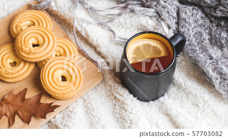 Autumn still life with cup of tea, cookies, sweater and leaves on a warm soft blanket. concept of cozy autumn, fall season Autumn still life with cup of tea, cookies, sweater and leaves on a warm soft blanket. concept of cozy autumn, fall season 57703082