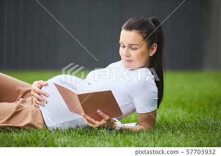 Pregnant woman relaxing with book Pregnant woman relaxing with book 57703932