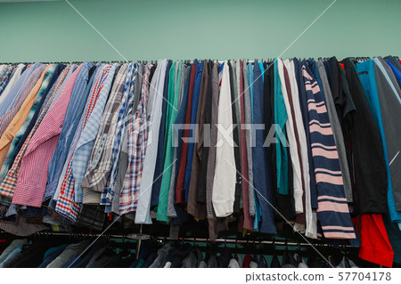 Colorful clothes on hangers in a store. 57704178
