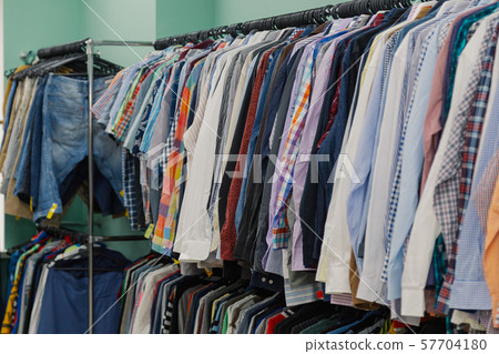 Colorful clothes on hangers in a store. 57704180