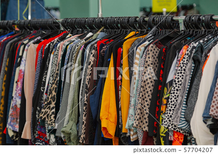 Colorful clothes on hangers in a store. Colorful clothes on hangers in a store. 57704207