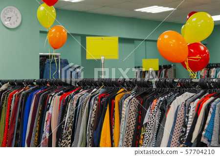 Colorful clothes on hangers in a store. Colorful clothes on hangers in a store. 57704210