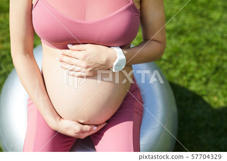 Pregnant woman doing fitness exercises Pregnant woman doing fitness exercises 57704329