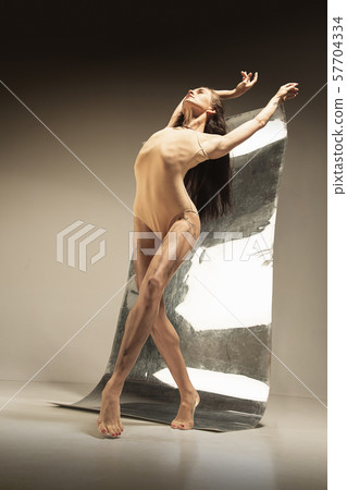 Young and stylish modern ballet dancer on brown background 57704334