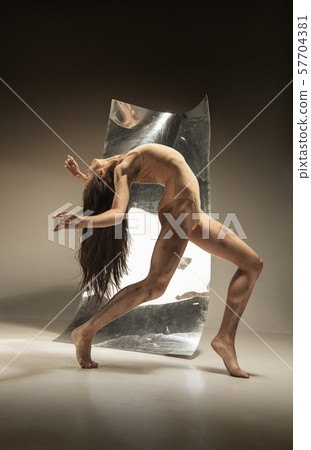 Young and stylish modern ballet dancer on brown background Young and stylish modern ballet dancer on brown background 57704381